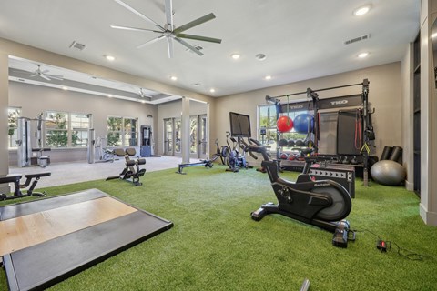 A home gym with a variety of equipment including a treadmill, weights, and a bench press.