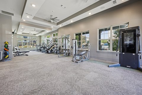 A spacious gym with a variety of equipment and a carpeted floor.