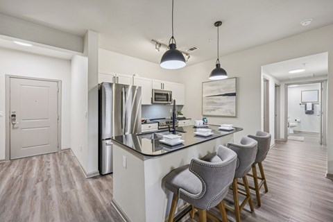 A modern kitchen with a center island and bar stools.