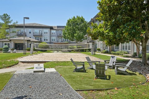 A playground area with a slide and seating area in front of a building.