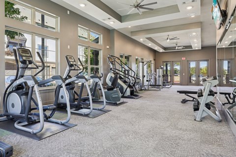A spacious gym with treadmills, elliptical machines, and other exercise equipment.