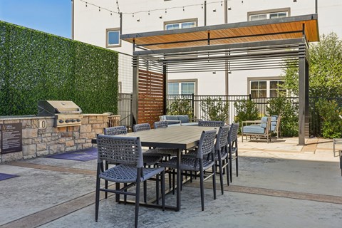 A patio with a table and chairs is set up outside a house.