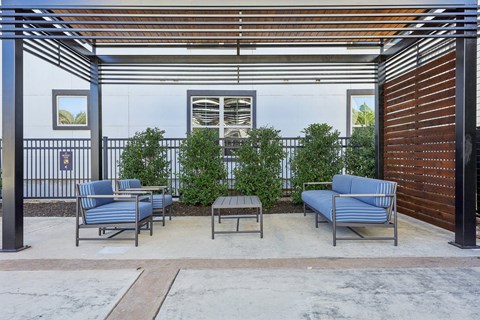 A patio with a table and chairs under a pergola.