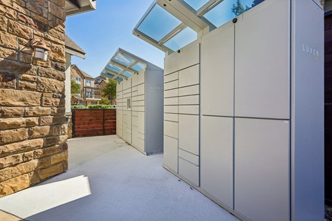 A modern outdoor kitchen with a glass roof and a white cabinet.
