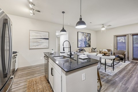 A modern kitchen with a refrigerator, sink, and a dining area.