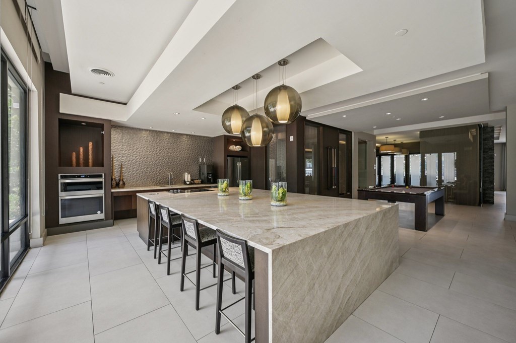 A modern kitchen with a large island and pendant lights at Everra Midtown Park Apartments, Dallas, TX, 75231