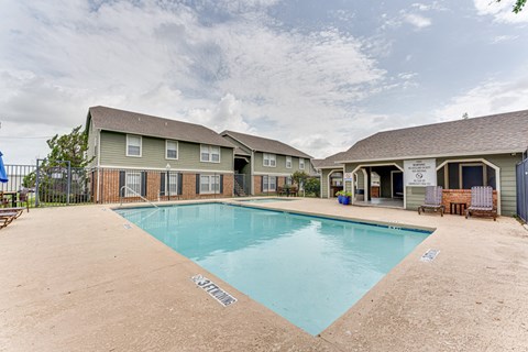 A swimming pool in front of a building with a sign that says