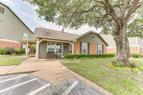 A house with a driveway and a tree in front.