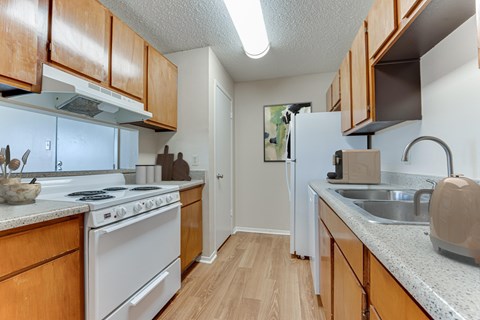 A kitchen with wooden cabinets and a white refrigerator.