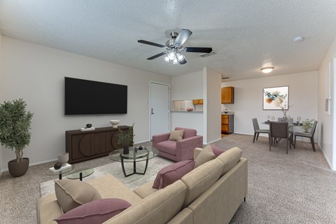 A living room with a beige couch and a ceiling fan.