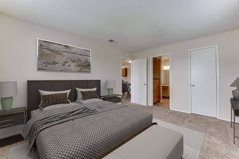 A bedroom with a large bed and a painting on the wall.