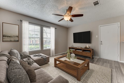 A living room with a brown sofa and a wooden coffee table.