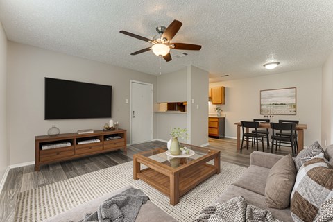 A living room with a grey couch and a wooden coffee table.