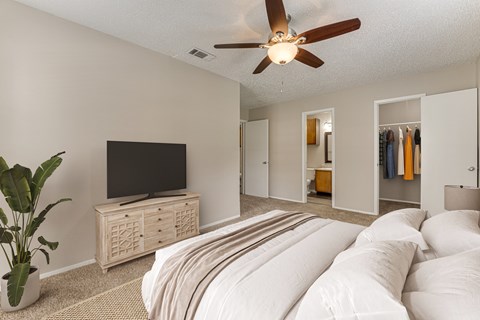 A bedroom with a large bed and a television.