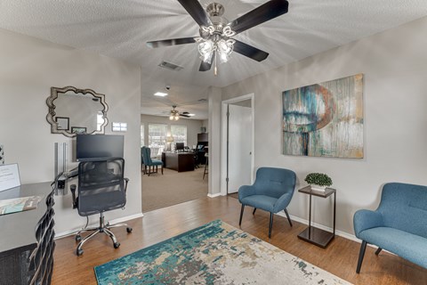 A room with a ceiling fan and a mirror on the wall.