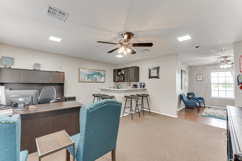 A living room with a blue chair and a ceiling fan.