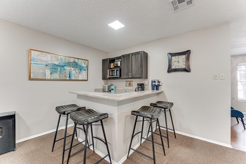 A kitchen with a bar area and two stools.