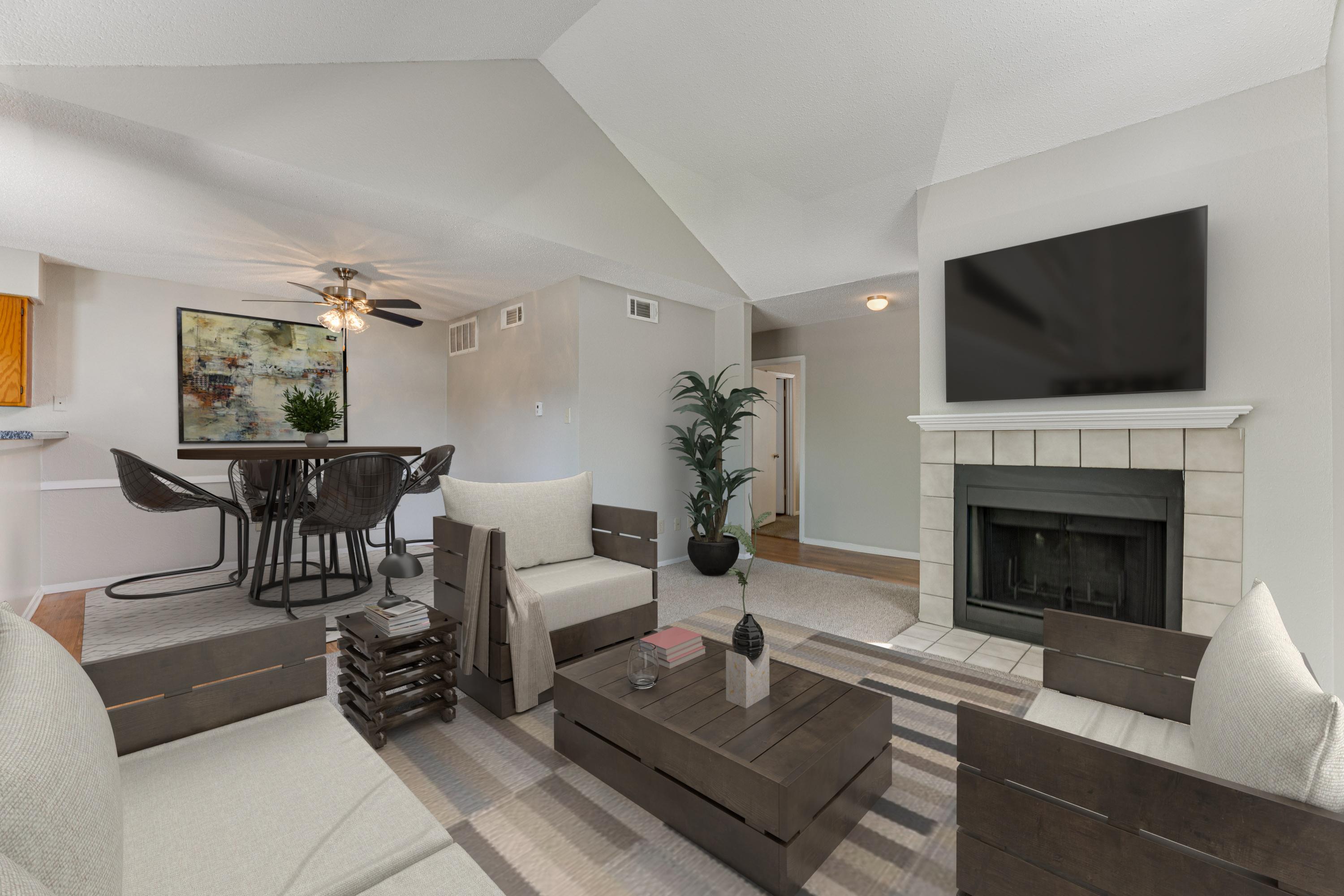A living room with a fireplace and a television mounted above it.
