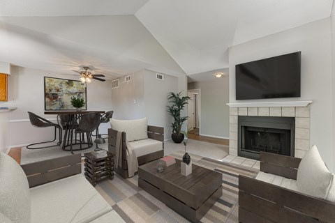 A living room with a fireplace and a television mounted above it.