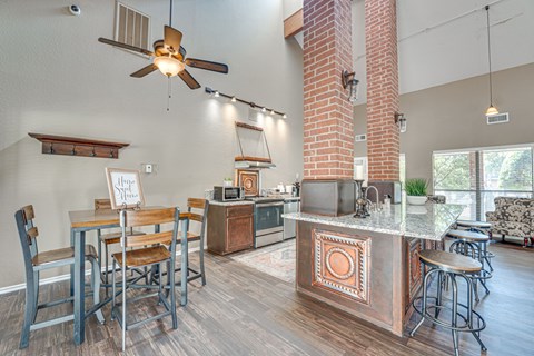 A kitchen with a bar and chairs.