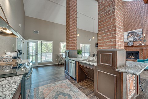 A kitchen with a brick chimney and a large island.