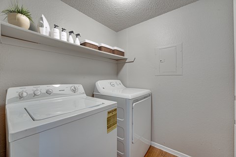 A white washing machine and dryer in a small laundry room.