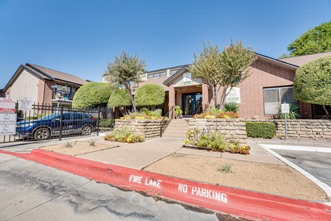 A red fire lane no parking zone in front of a building.