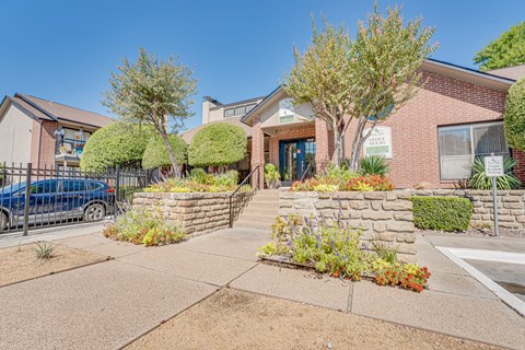 A blue car is parked in front of a house.