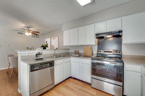 A modern kitchen with stainless steel appliances and white cabinets.