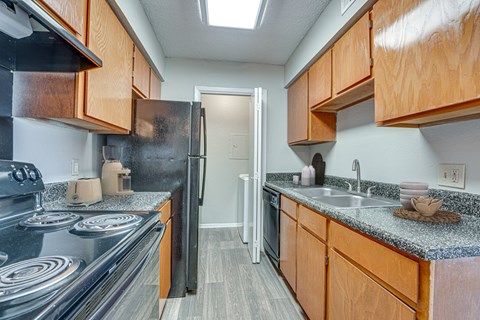 A kitchen with wooden cabinets and a black stove top.