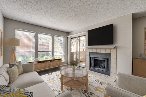 A living room with a fireplace and a flat screen TV mounted above it.