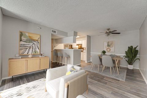 A living room with a white couch and a wooden floor.
