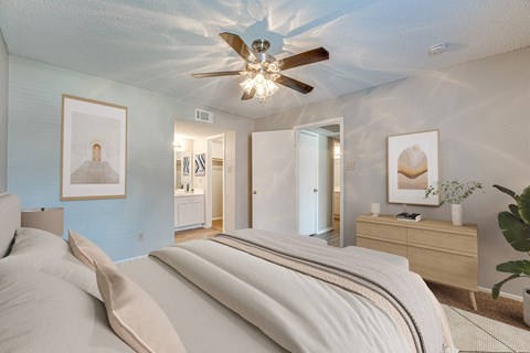 A bedroom with a large bed and a ceiling fan.