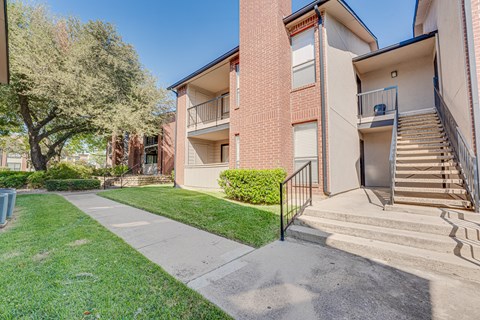A building with a red brick facade and a balcony with a metal railing.