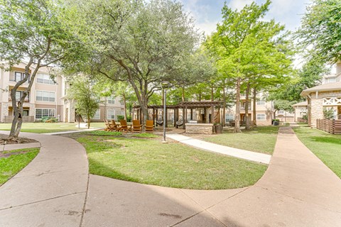 A park with a walkway and trees. at The Brazos, Dallas, Texas