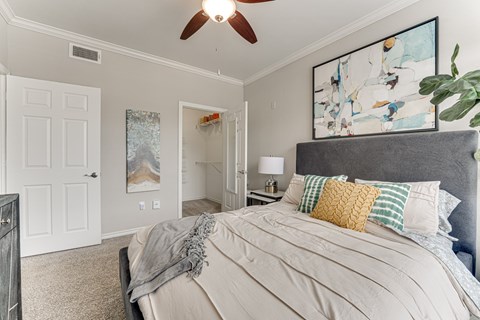 A bedroom with a large bed and a ceiling fan.