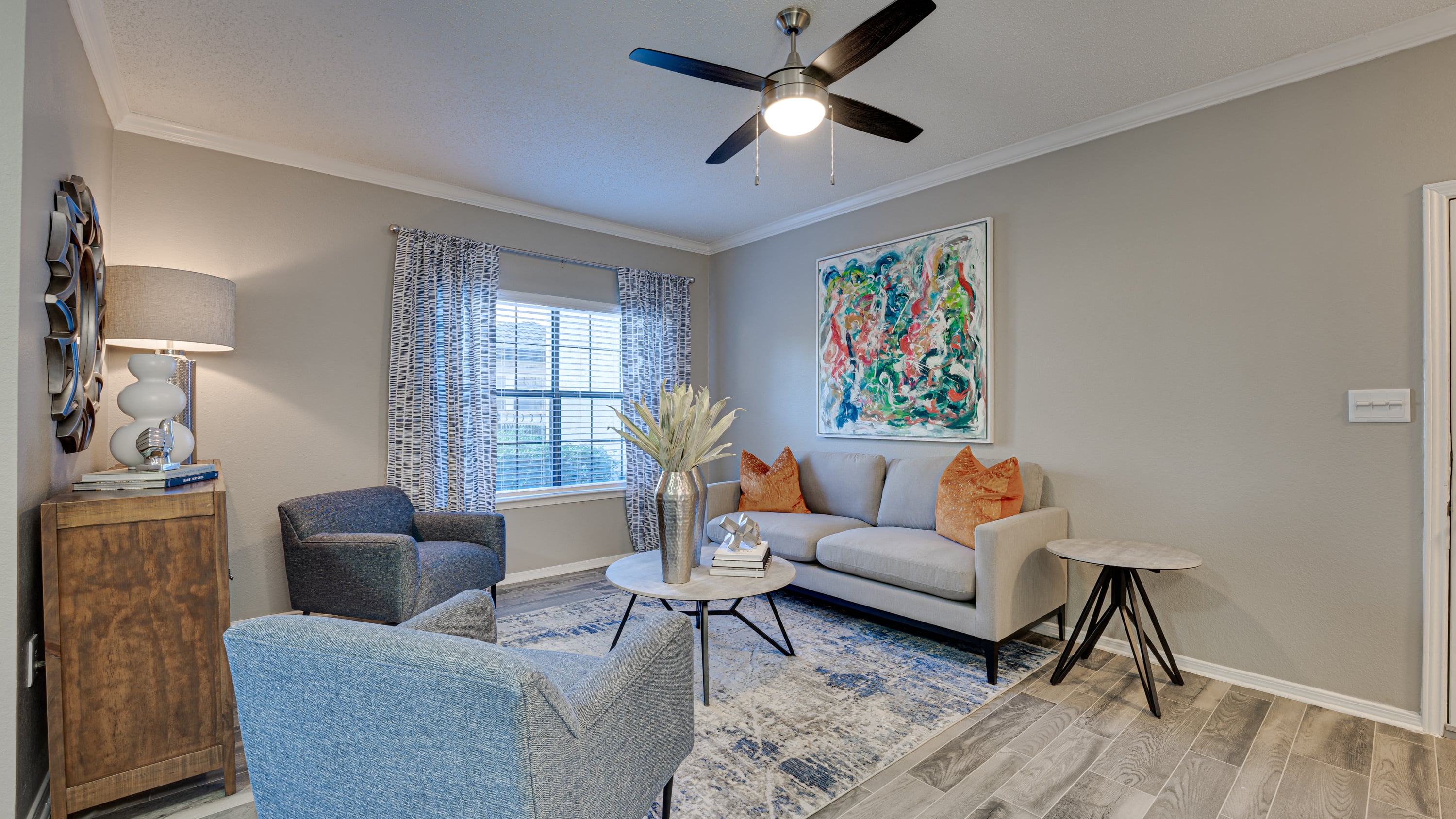 an open living room with couches and chairs and a ceiling fan