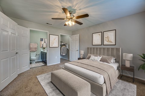 A bedroom with a large bed and a ceiling fan.