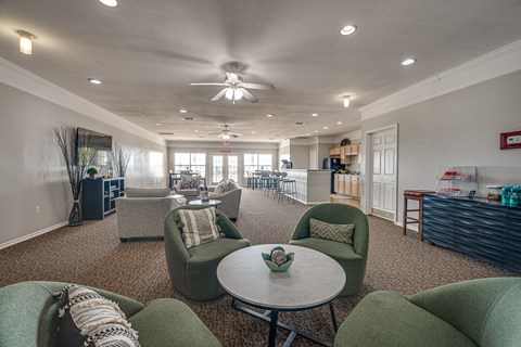 A living room with a ceiling fan and a table with chairs.
