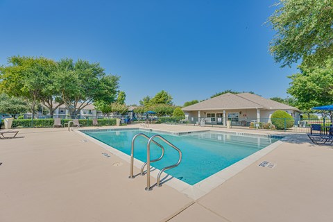 A large outdoor swimming pool with a diving board.