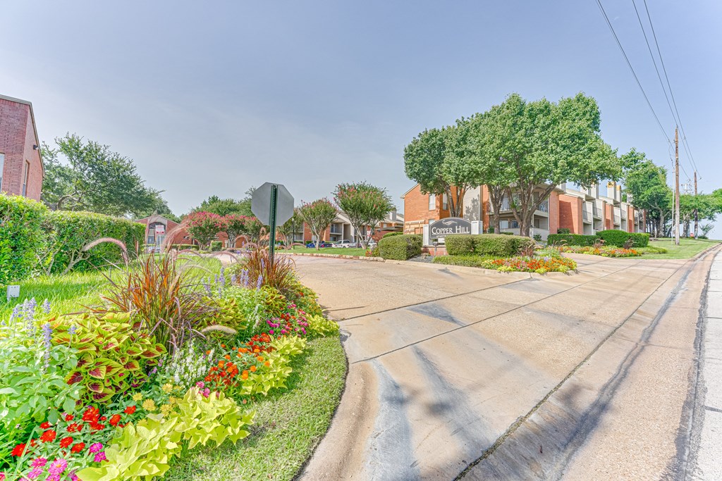A street view with a stop sign and a building in the background at Copper Hill Apartments, Bedford, TX