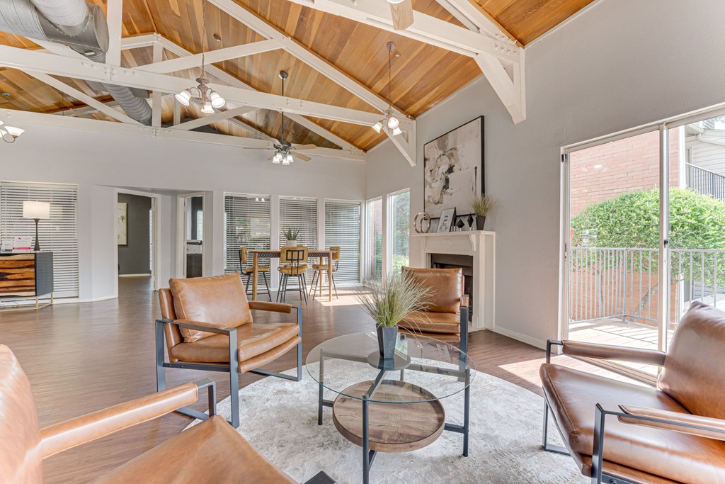 A living room with brown leather chairs and a wooden coffee table at Copper Hill Apartments, Bedford, TX, 76021