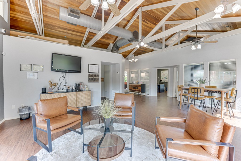 A living room with a brown leather couch and a glass coffee table at Copper Hill Apartments, Bedford, TX
