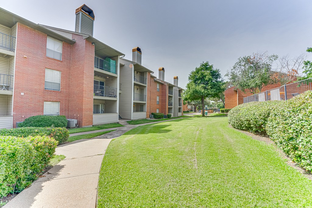 A grassy area in front of apartment buildings at Copper Hill Apartments, Texas