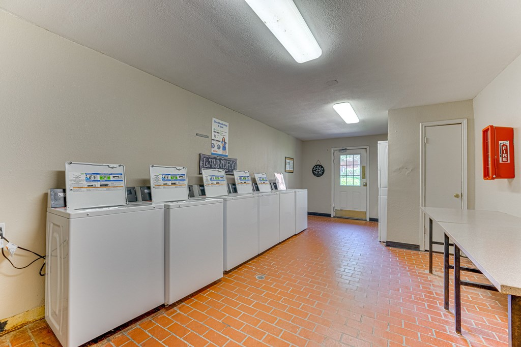 A room with a row of refrigerators and a fire extinguisher at Copper Hill Apartments, Bedford