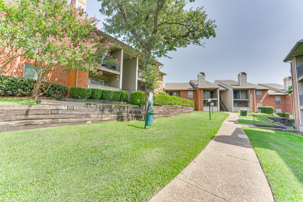 A residential area with apartment buildings and a well-maintained lawn at Copper Hill Apartments, Bedford