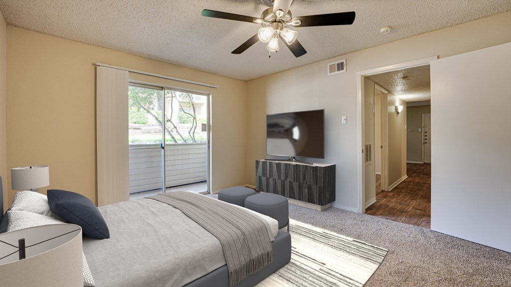 A bedroom with a bed, a ceiling fan, and a television at Copper Hill Apartments, Bedford