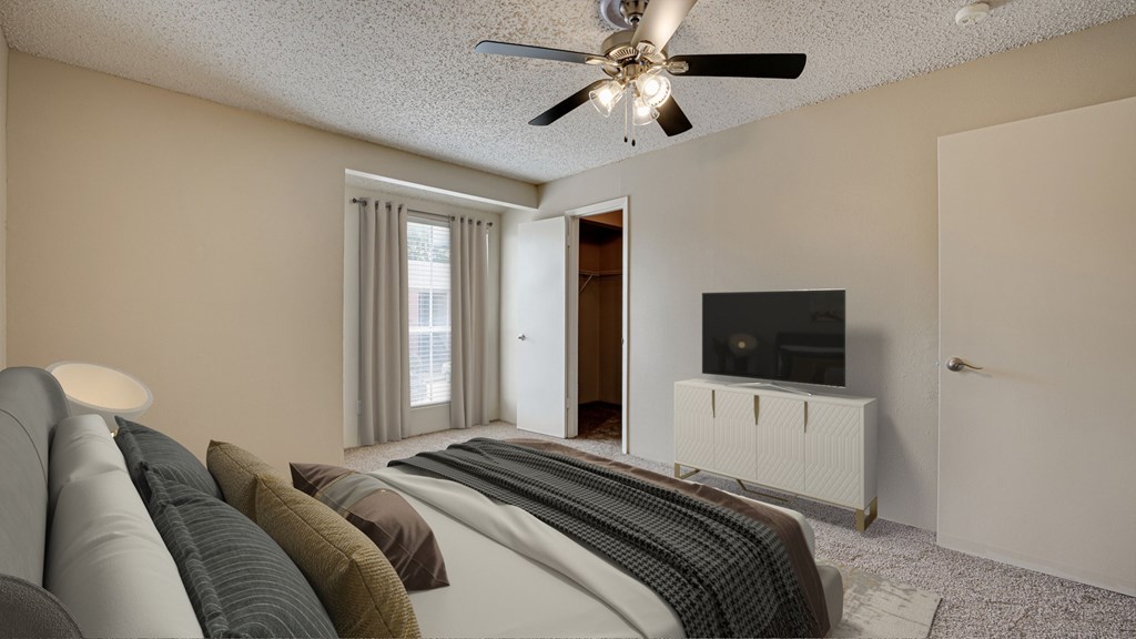 A living room with a grey sofa and a ceiling fan at Copper Hill Apartments, Bedford, TX