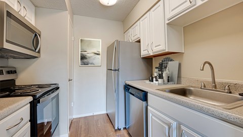 A kitchen with a refrigerator, stove, and dishwasher.