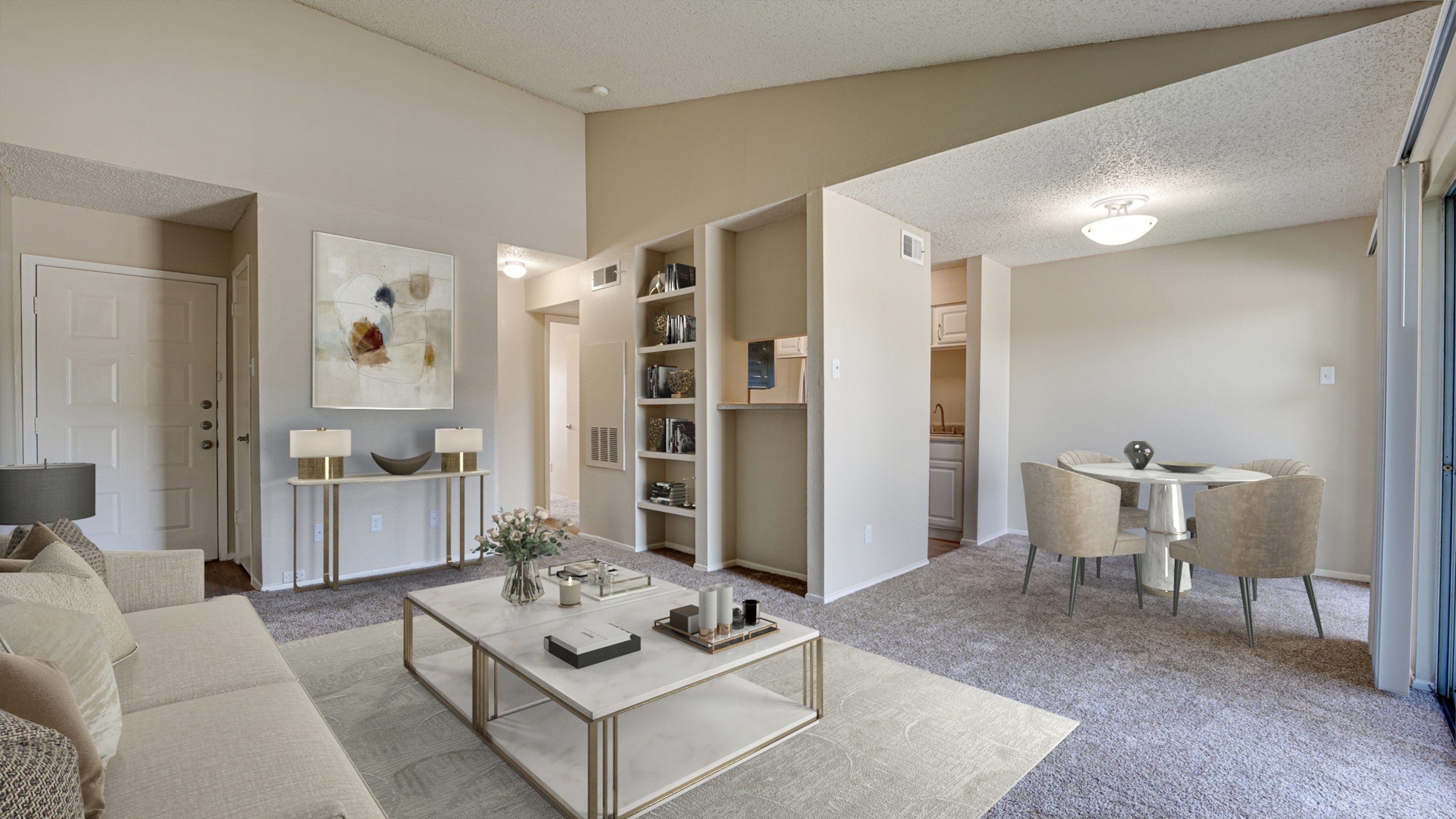 A living room with a white sofa, a coffee table, and a dining table with chairs.